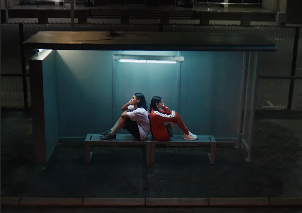 Couple outside at night in bus shelter