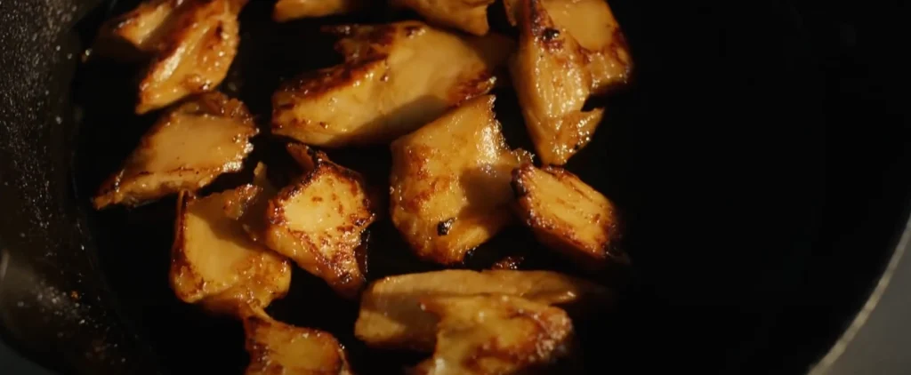 Browned meat chunks in a cooking pan